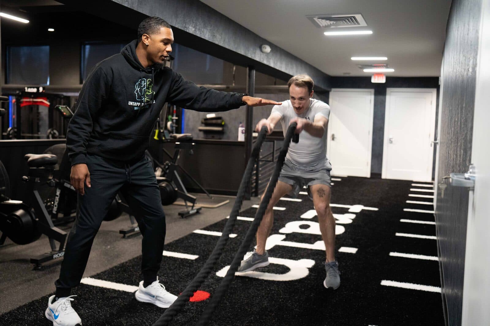 Terrence coaching a client on battle ropes at Untapped Potential Performance